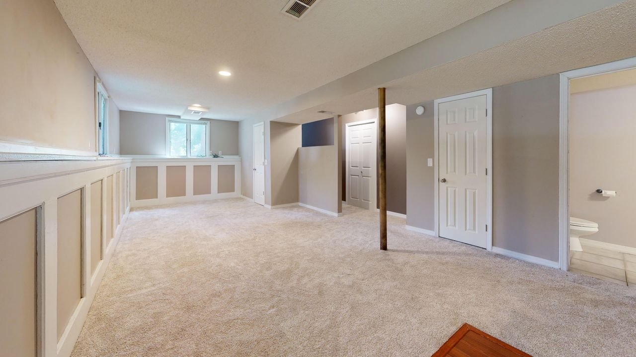Mastering the First Impression: Your intriguing post title goes here Bright and clean modern basement with carpet flooring and recessed lighting.